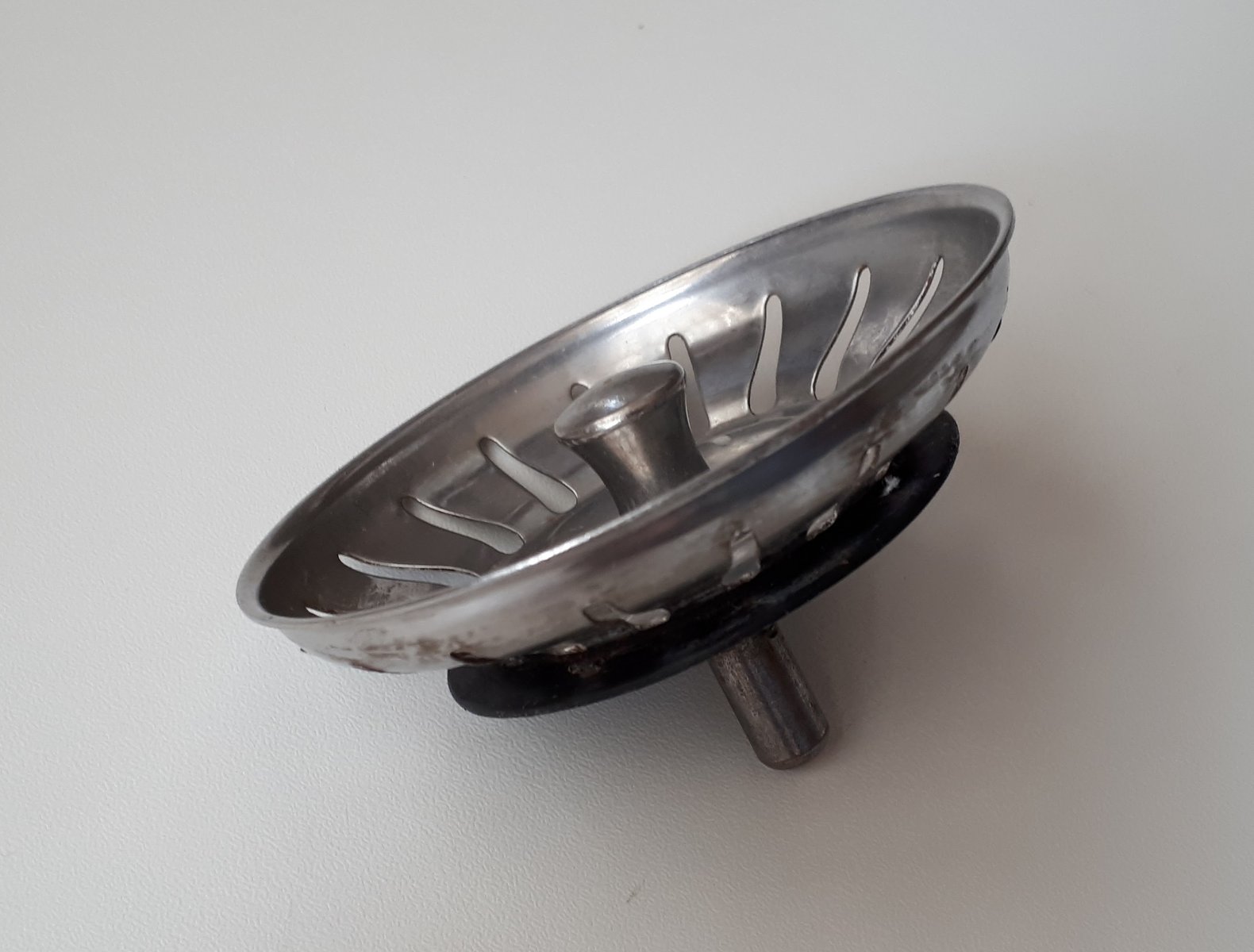 A stainless steel basket strainer for a kitchen sink plughole, used to catch food scraps before they reach the waste pipe